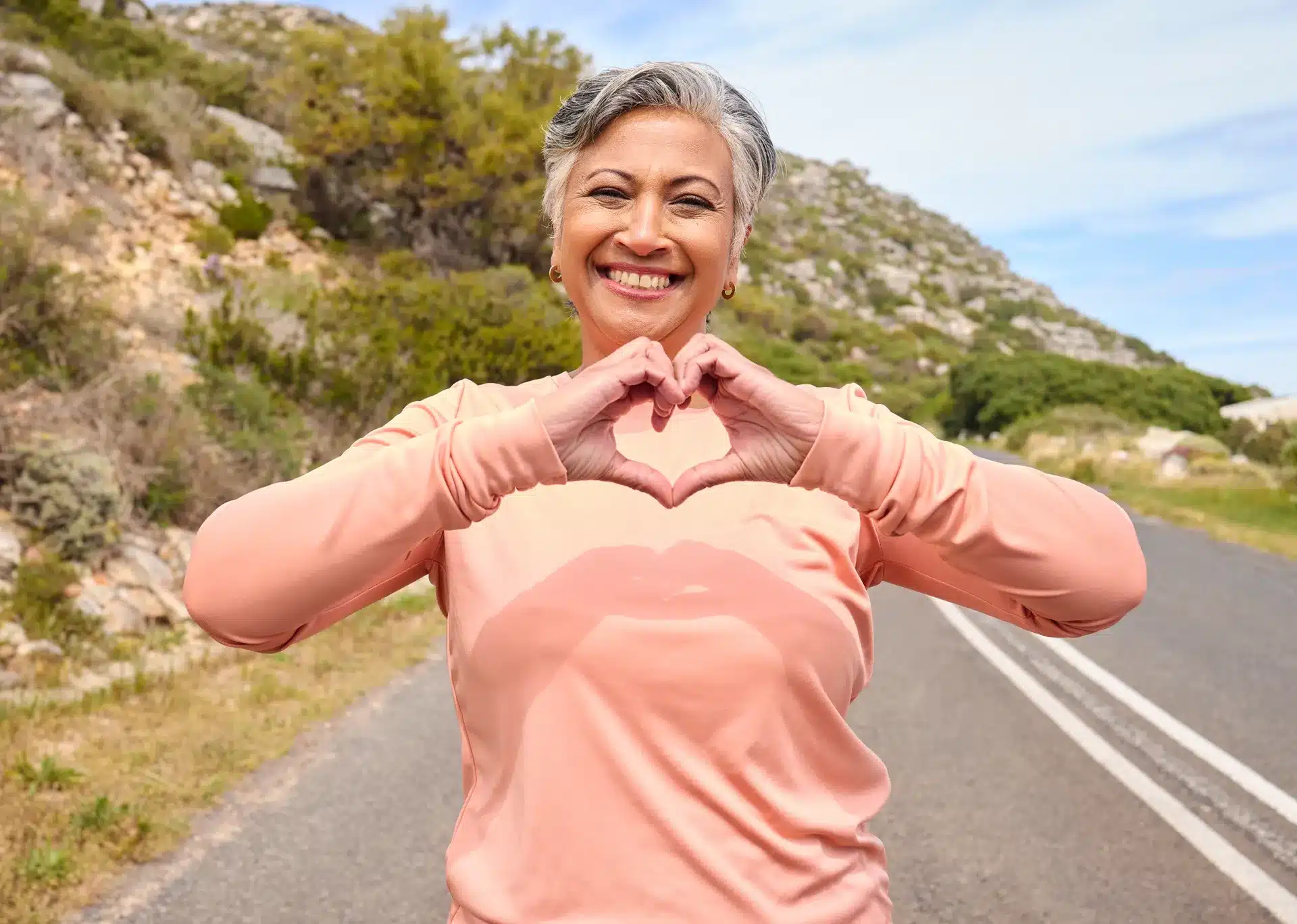 A happy customer making a heart with her hands